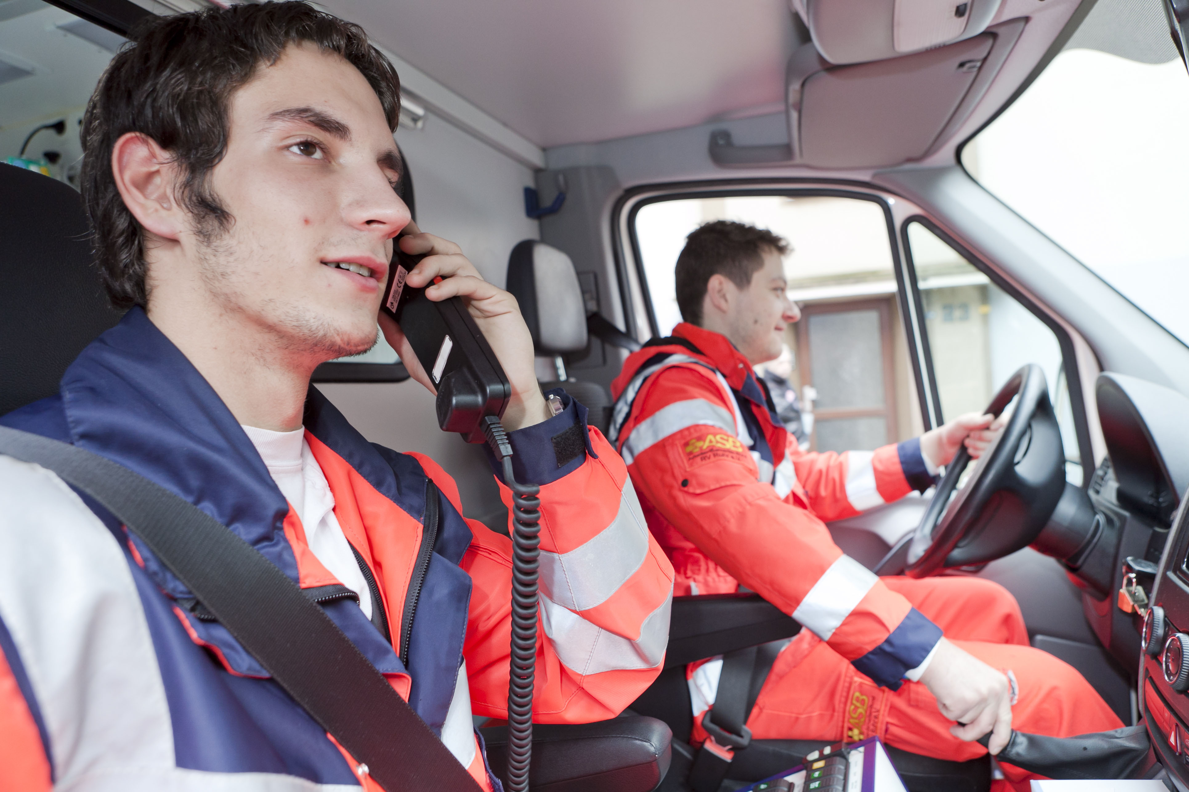 Zwei Rettungsdienstmitarbeiter sitzen im Rettungsfahrzeug