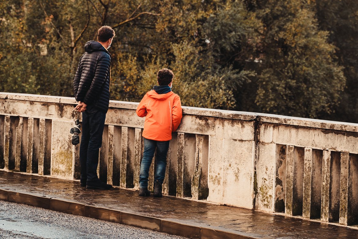 Vater und Sohn stehen auf einer Brücke