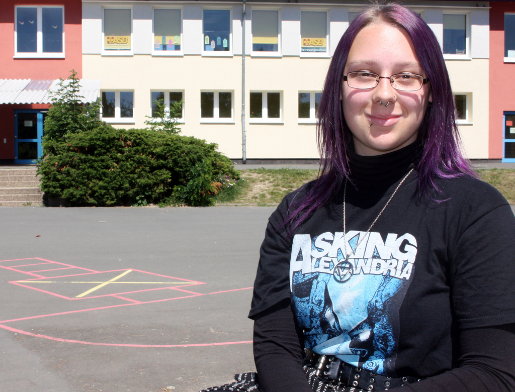 Leoni steht vor dem Schulgebäude